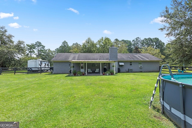 back of property featuring a yard and cooling unit