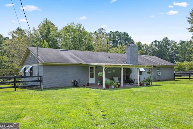 rear view of property with a patio area and a yard