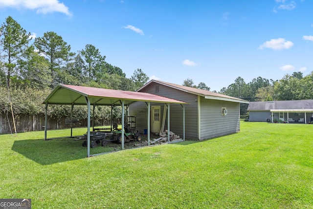 rear view of property with a carport and a lawn