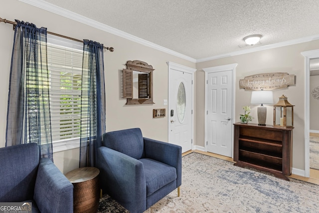 living area with a textured ceiling, light hardwood / wood-style flooring, and ornamental molding