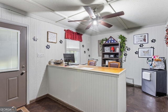 kitchen featuring ceiling fan, wood walls, and kitchen peninsula