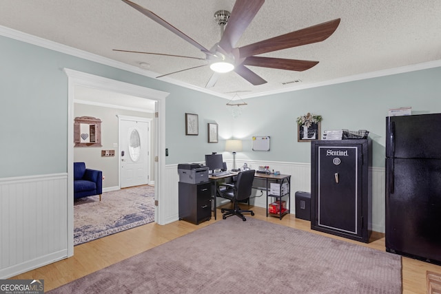 office area with a textured ceiling, light hardwood / wood-style flooring, and ornamental molding