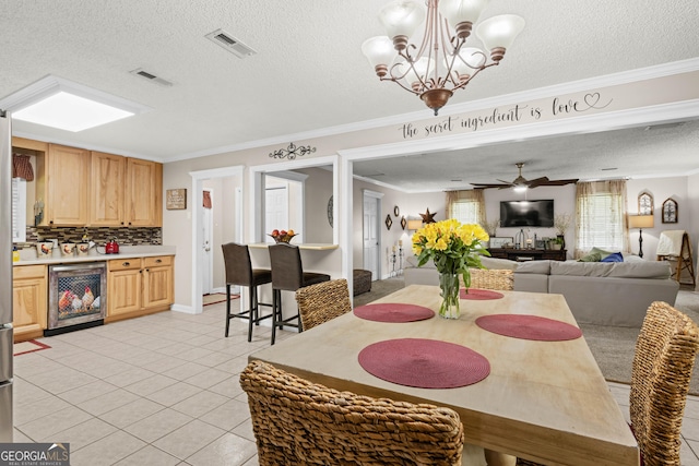 dining space featuring a textured ceiling, light tile patterned floors, beverage cooler, and ornamental molding