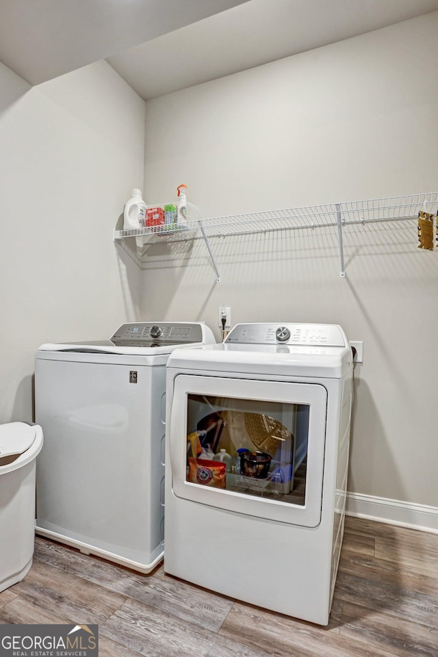 laundry area featuring separate washer and dryer and hardwood / wood-style floors