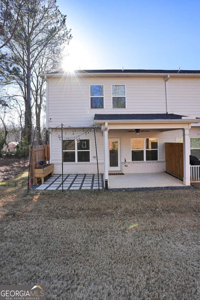 rear view of house featuring a lawn and a patio