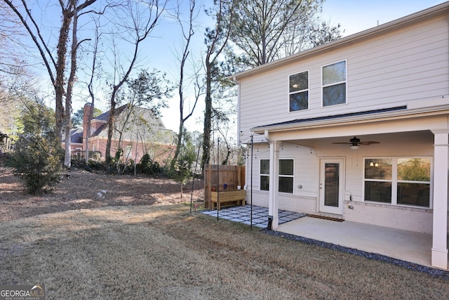 rear view of house featuring ceiling fan, a patio, and a yard