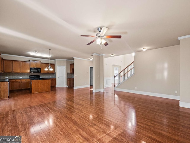 unfurnished living room with ceiling fan, crown molding, and dark wood-type flooring