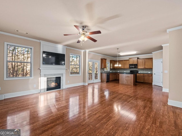 unfurnished living room with ornamental molding and a healthy amount of sunlight