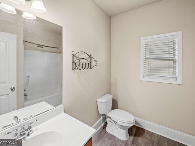 full bathroom with hardwood / wood-style flooring, toilet, vanity, and bathing tub / shower combination