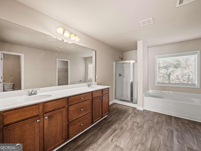 bathroom featuring hardwood / wood-style flooring, independent shower and bath, and vanity