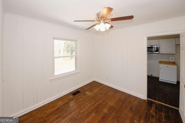 spare room featuring ceiling fan and dark hardwood / wood-style flooring