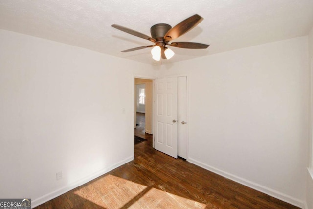 unfurnished room featuring ceiling fan and dark hardwood / wood-style floors