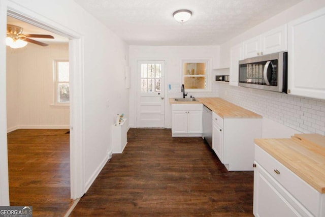 kitchen featuring wood counters, white cabinetry, stainless steel appliances, sink, and dark hardwood / wood-style floors