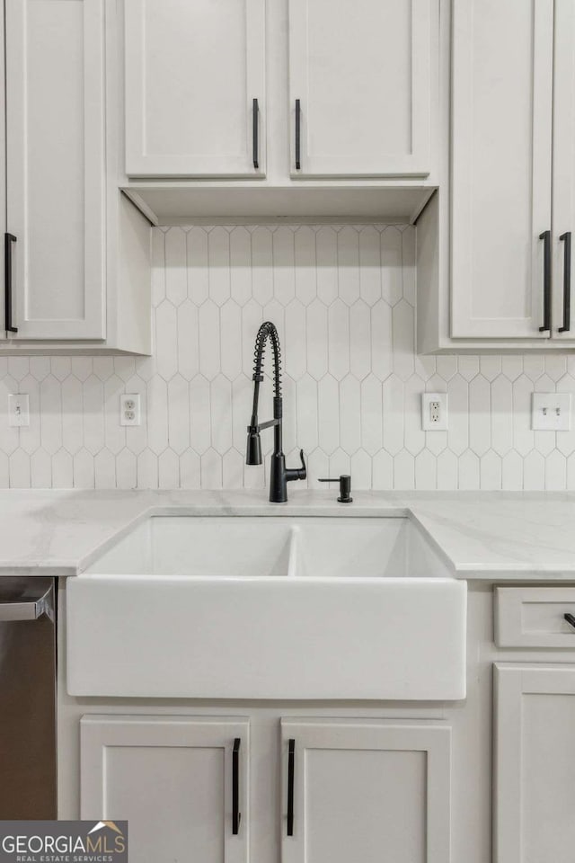 kitchen featuring sink, white cabinetry, and tasteful backsplash