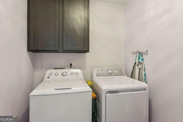 washroom with independent washer and dryer and cabinets