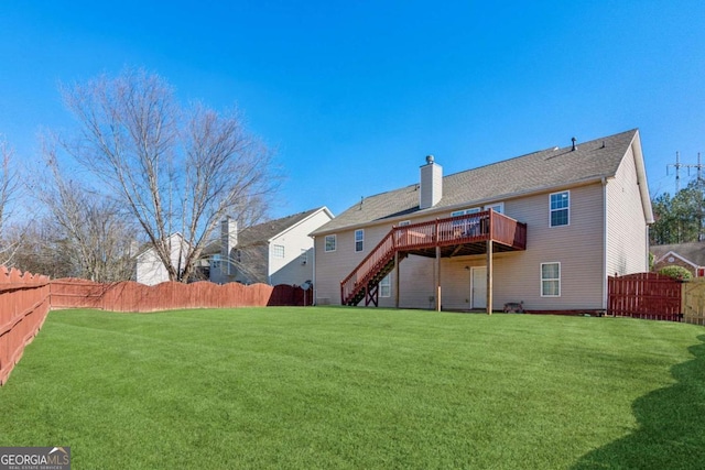 rear view of house featuring a lawn and a deck