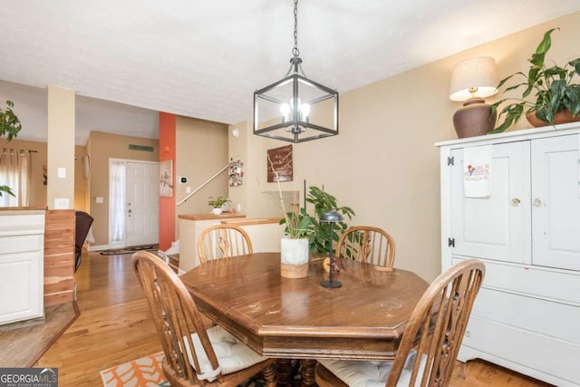 dining area featuring light hardwood / wood-style flooring and an inviting chandelier