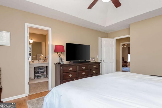 bedroom with ceiling fan, connected bathroom, and light hardwood / wood-style flooring