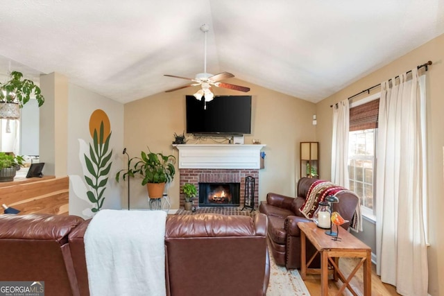 living room featuring a brick fireplace, light hardwood / wood-style floors, ceiling fan, and vaulted ceiling