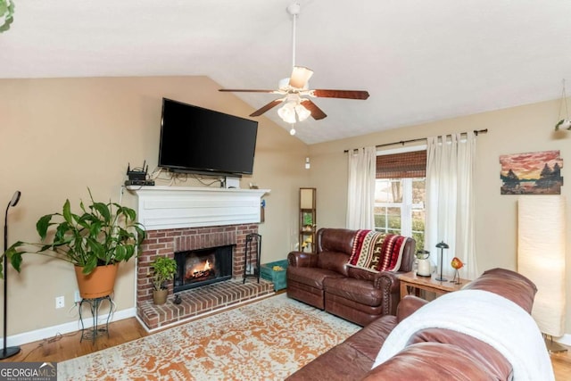 living room with a fireplace, hardwood / wood-style flooring, vaulted ceiling, and ceiling fan