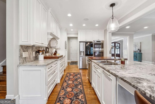 kitchen featuring sink, decorative light fixtures, and white cabinets