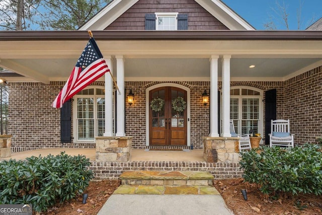 entrance to property featuring covered porch and french doors