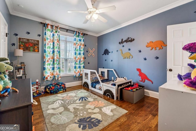 rec room featuring ceiling fan, crown molding, and dark hardwood / wood-style flooring