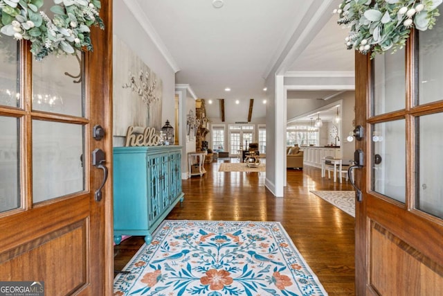 foyer entrance with crown molding and dark hardwood / wood-style flooring