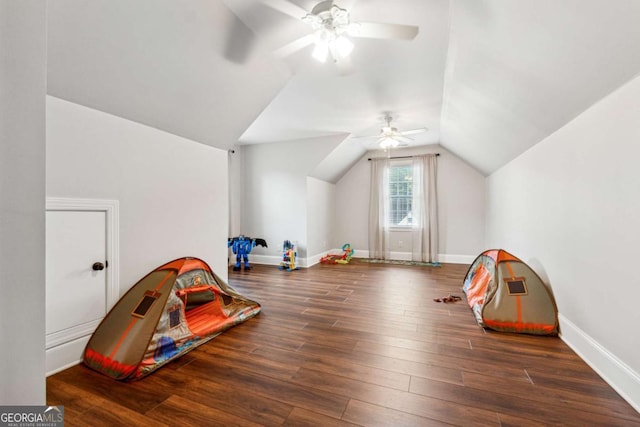 rec room featuring vaulted ceiling, ceiling fan, and dark wood-type flooring