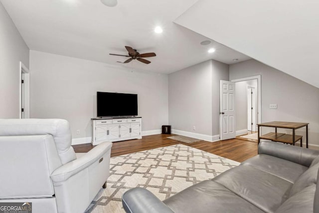 living room featuring hardwood / wood-style flooring, ceiling fan, and vaulted ceiling