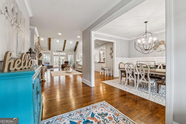 entrance foyer featuring a notable chandelier, hardwood / wood-style flooring, vaulted ceiling with beams, and crown molding