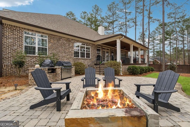 view of patio with an outdoor fire pit, an outdoor kitchen, and grilling area