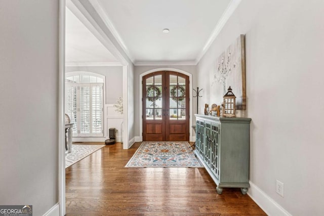 entrance foyer with dark hardwood / wood-style floors, crown molding, and french doors