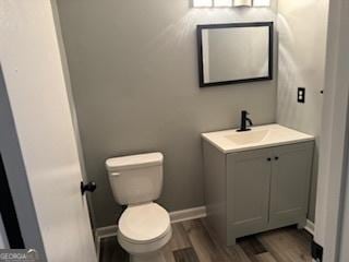 bathroom featuring vanity, toilet, and hardwood / wood-style floors