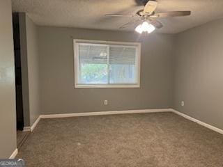 empty room with ceiling fan and dark carpet