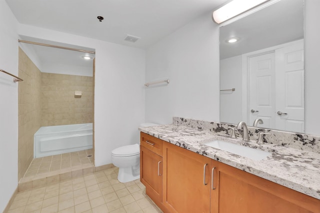 full bathroom featuring toilet, vanity, tiled shower / bath, and tile patterned flooring