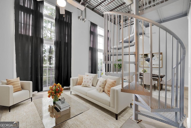 living room featuring ceiling fan and a high ceiling