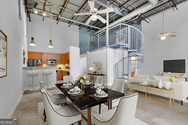 dining room featuring ceiling fan and a high ceiling