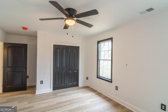 unfurnished bedroom featuring a closet, ceiling fan, and light hardwood / wood-style flooring