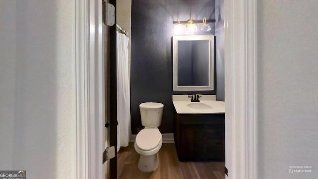 bathroom with vanity, toilet, and hardwood / wood-style flooring