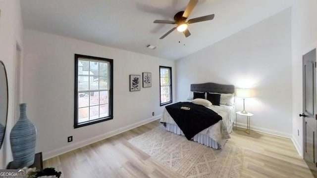 bedroom featuring ceiling fan, lofted ceiling, and light wood-type flooring