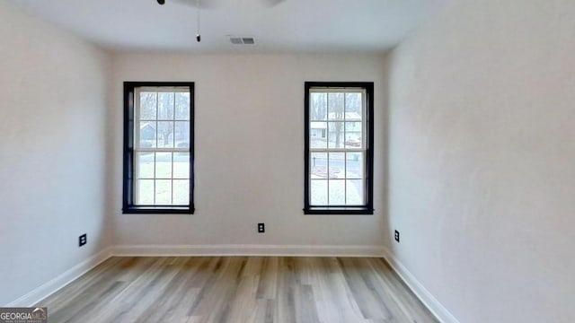 empty room featuring light hardwood / wood-style flooring and a wealth of natural light