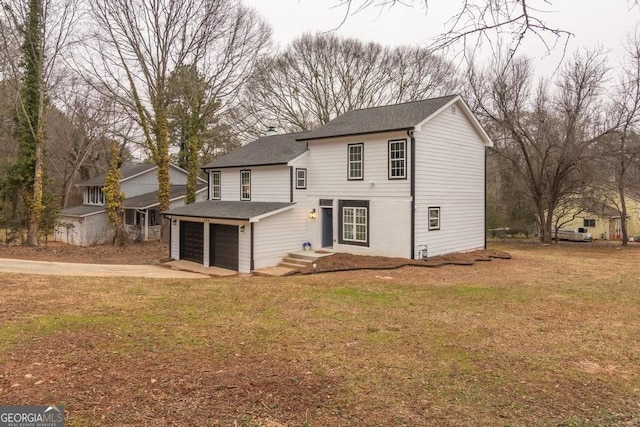 view of property featuring a garage and a front yard