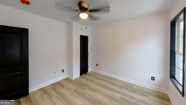 empty room with ceiling fan and light hardwood / wood-style floors