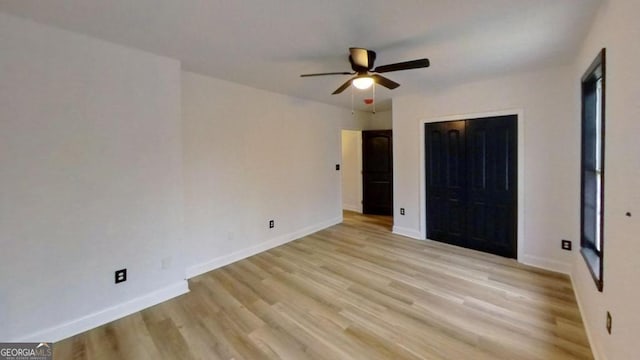 unfurnished bedroom featuring ceiling fan, a closet, and light wood-type flooring