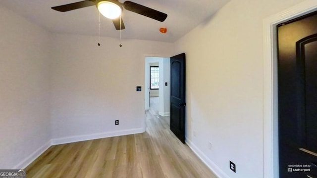 spare room with light wood-type flooring and ceiling fan