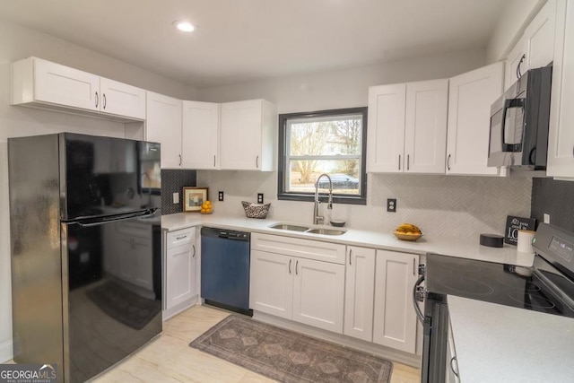 kitchen with black appliances, white cabinetry, decorative backsplash, and sink