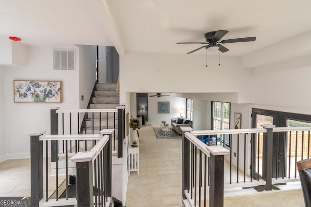 stairway featuring ceiling fan