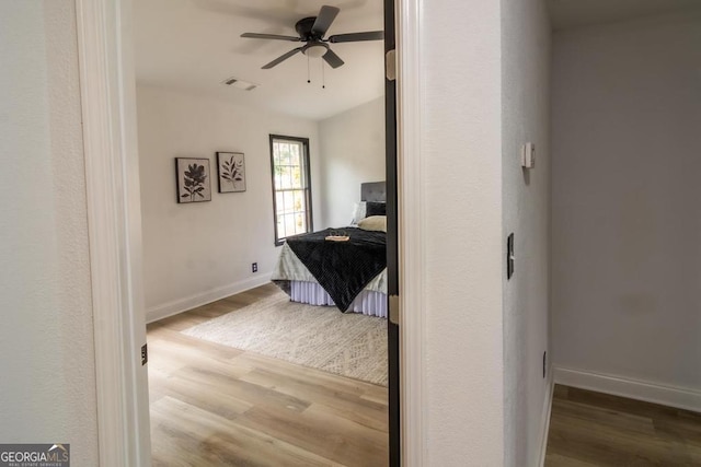 bedroom with ceiling fan and wood-type flooring