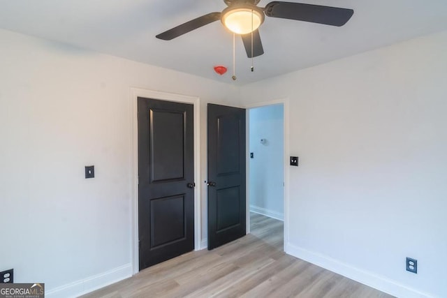 unfurnished bedroom with ceiling fan and light hardwood / wood-style floors